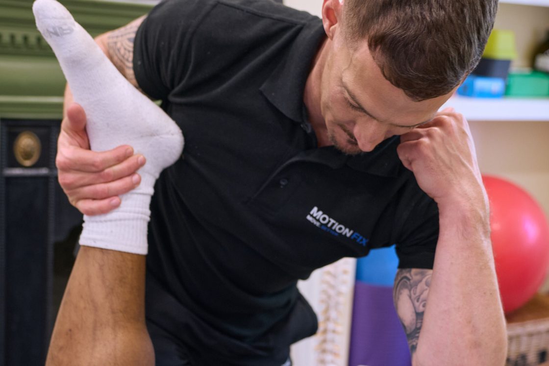Chiropractor performing a straight-leg assessment for sciatica at MotionFix, Elephant & Castle