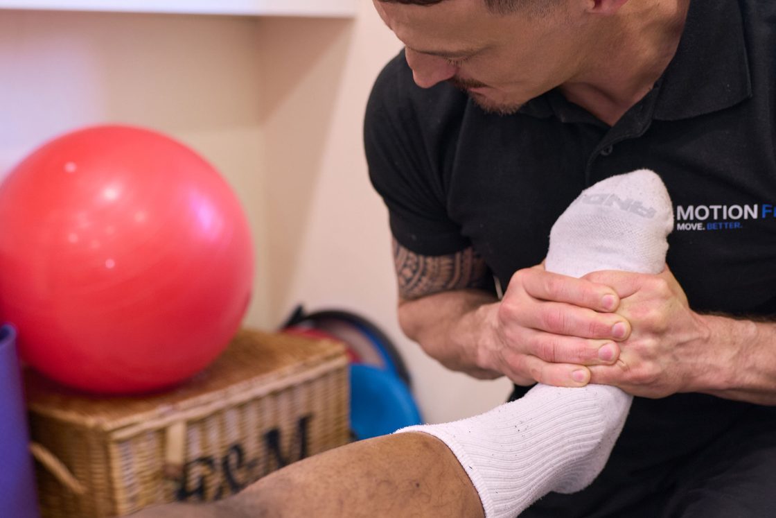 Chiropractor assessing a patient's foot and ankle at MotionFix, Elephant & Castle