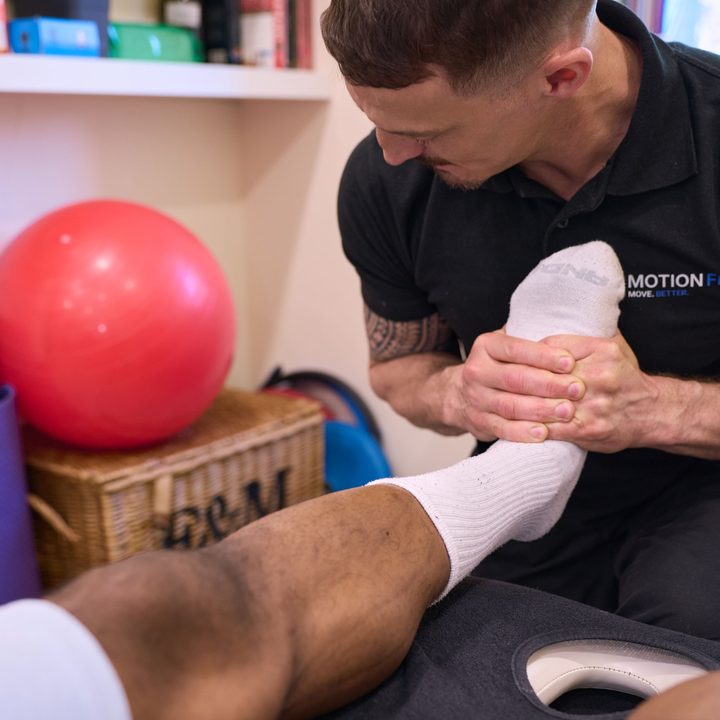Chiropractor assessing a patient's foot and ankle at MotionFix